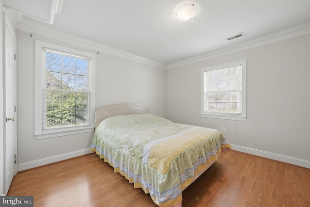 bedroom with visible vents, baseboards, and wood finished floors