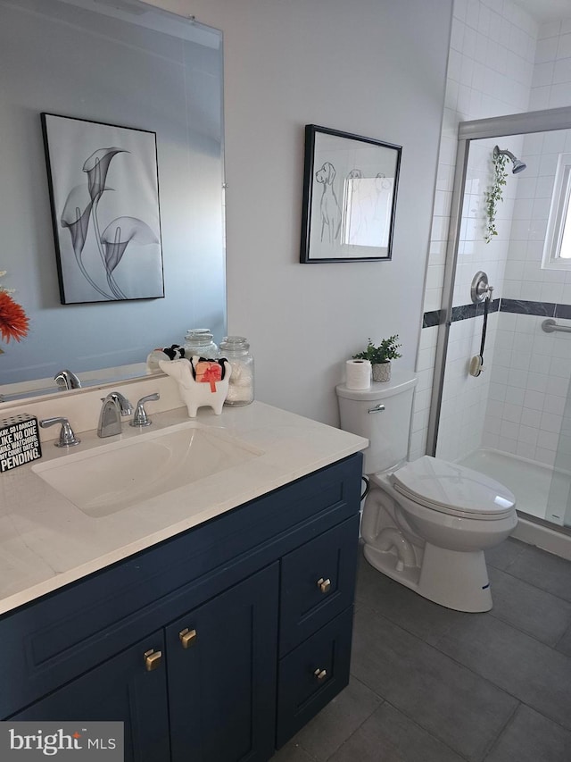 full bathroom with toilet, a stall shower, tile patterned flooring, and vanity