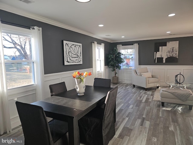 dining area with plenty of natural light, crown molding, and wood finished floors