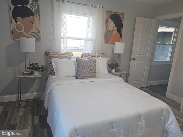 bedroom featuring dark wood-style flooring and baseboards