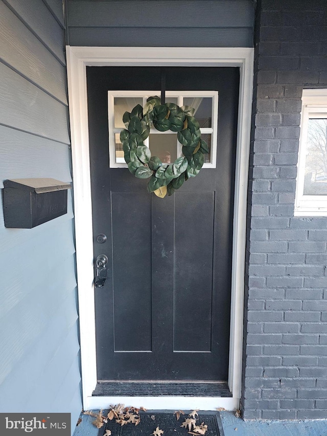 doorway to property featuring brick siding