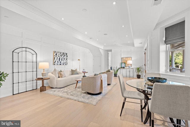 living room with ornamental molding and light hardwood / wood-style flooring