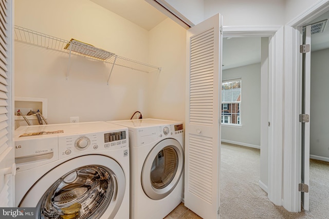 clothes washing area with independent washer and dryer and light colored carpet