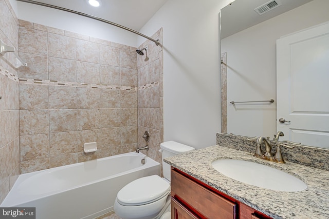 full bathroom featuring tiled shower / bath combo, toilet, and vanity