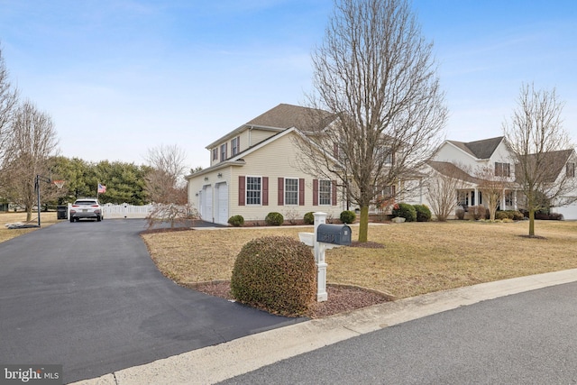 view of front of house with driveway, a garage, and a front lawn