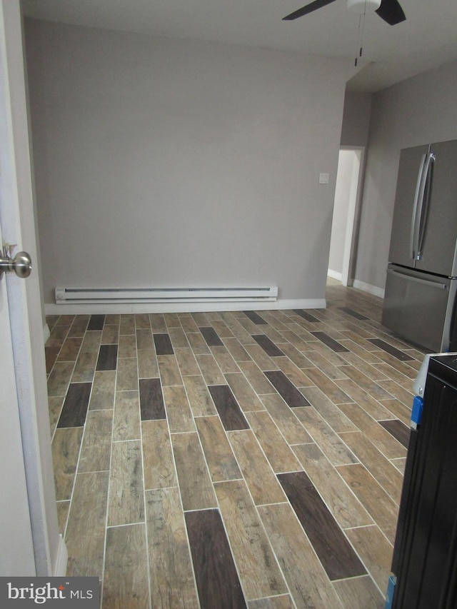 spare room with ceiling fan, wood finish floors, baseboard heating, and baseboards