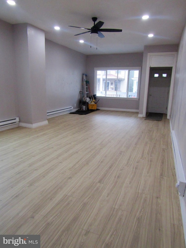 interior space with light wood finished floors, a baseboard radiator, and recessed lighting