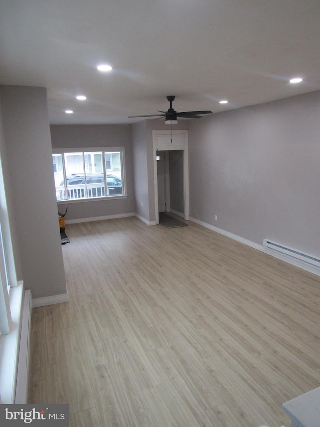 unfurnished living room with recessed lighting, baseboards, light wood finished floors, and baseboard heating