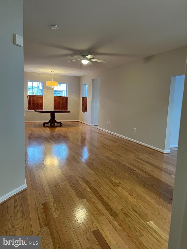 spare room with ceiling fan, baseboards, and wood finished floors