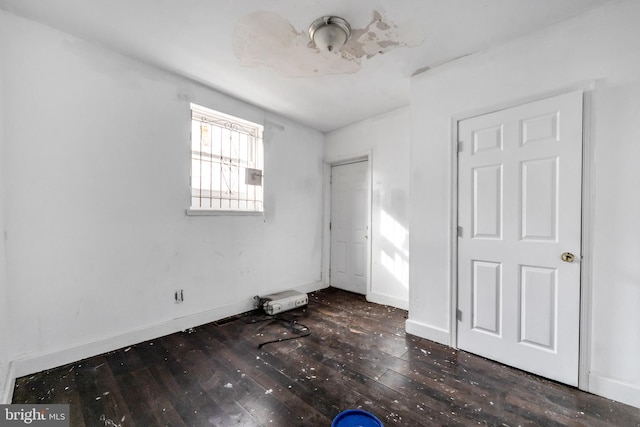 unfurnished bedroom with dark hardwood / wood-style flooring