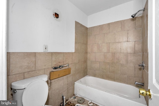 bathroom with tile walls and toilet