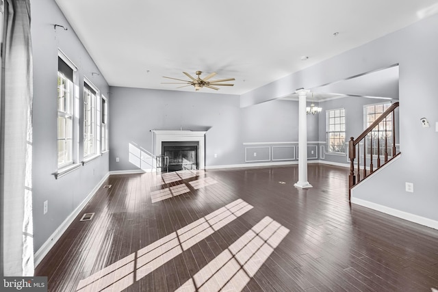 unfurnished living room featuring a fireplace with flush hearth, visible vents, ornate columns, and wood finished floors