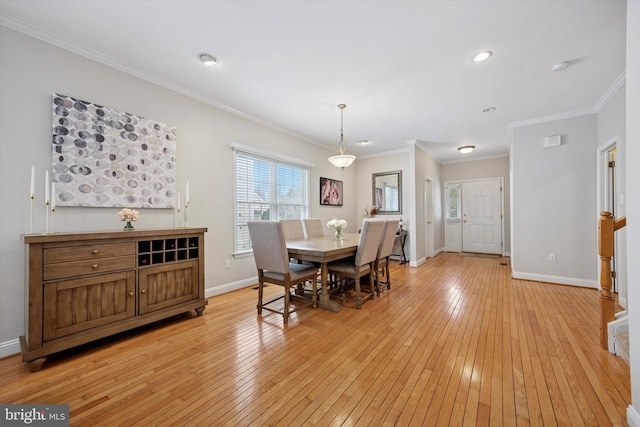 dining room featuring light wood-style floors, baseboards, and crown molding