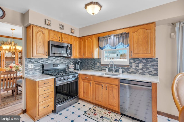 kitchen with decorative light fixtures, a notable chandelier, sink, appliances with stainless steel finishes, and decorative backsplash