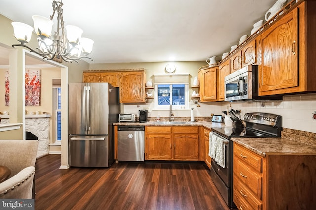 kitchen with dark hardwood / wood-style flooring, decorative light fixtures, sink, tasteful backsplash, and appliances with stainless steel finishes