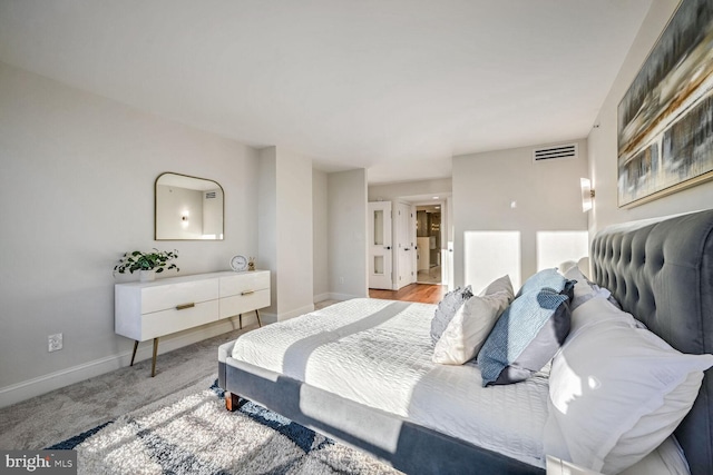 carpeted bedroom featuring baseboards and visible vents