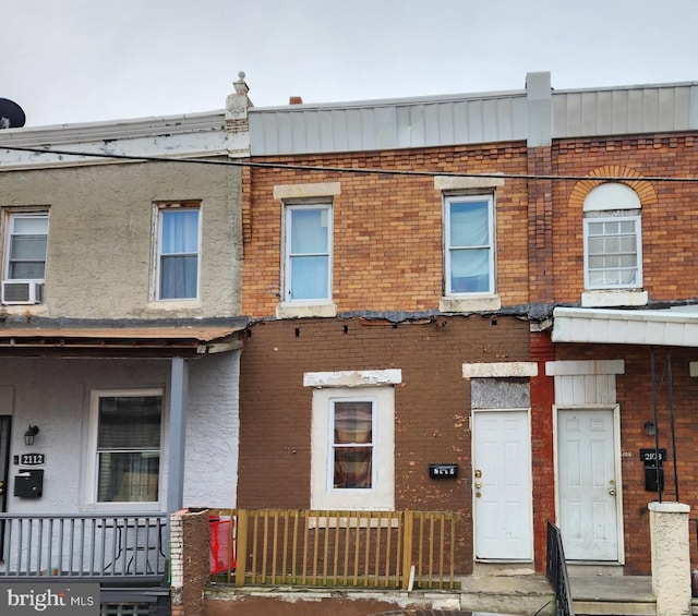 view of property featuring brick siding and cooling unit