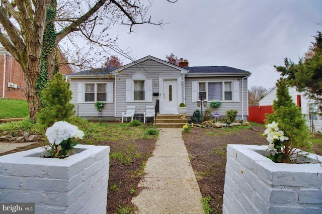 view of front of home with a chimney and fence