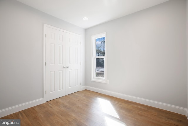 unfurnished bedroom with a closet and light hardwood / wood-style flooring