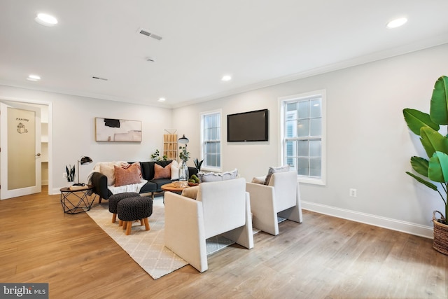 living room with light hardwood / wood-style floors and ornamental molding