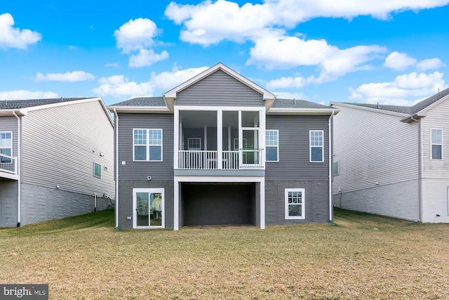 back of property with a sunroom and a lawn