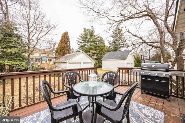 wooden terrace featuring outdoor dining space, a grill, and an outbuilding