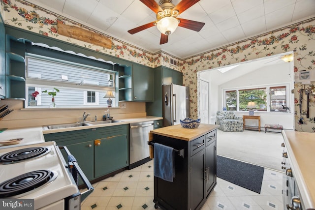 kitchen with wallpapered walls, green cabinets, wood counters, stainless steel appliances, and open shelves