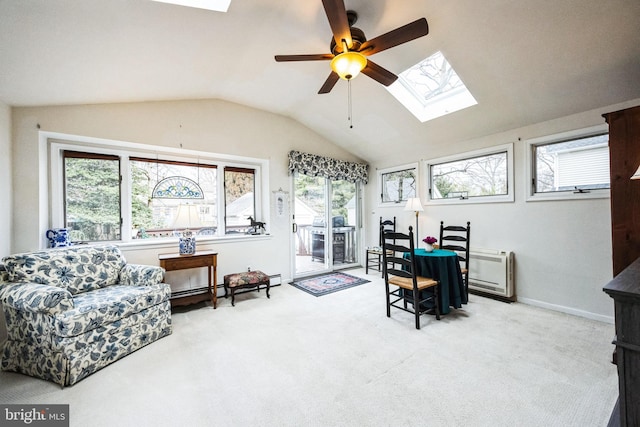 interior space with ceiling fan, baseboards, baseboard heating, heating unit, and lofted ceiling with skylight