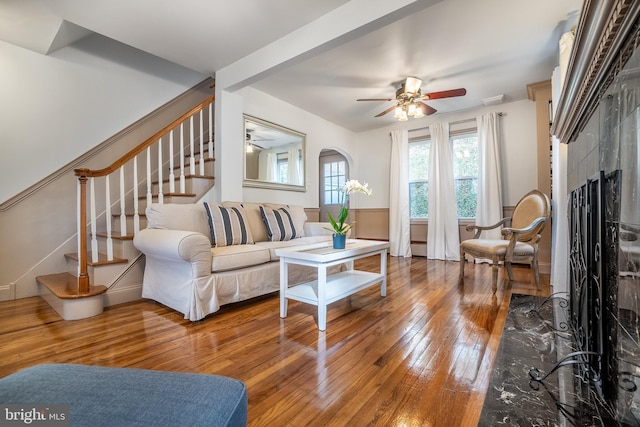 living room featuring a tile fireplace, hardwood / wood-style flooring, and ceiling fan