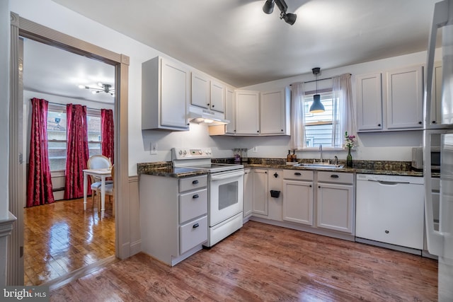 kitchen featuring sink, white appliances, white cabinetry, and decorative light fixtures