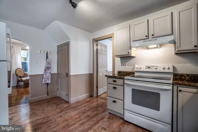 kitchen with electric range, dark stone countertops, and dark wood-type flooring