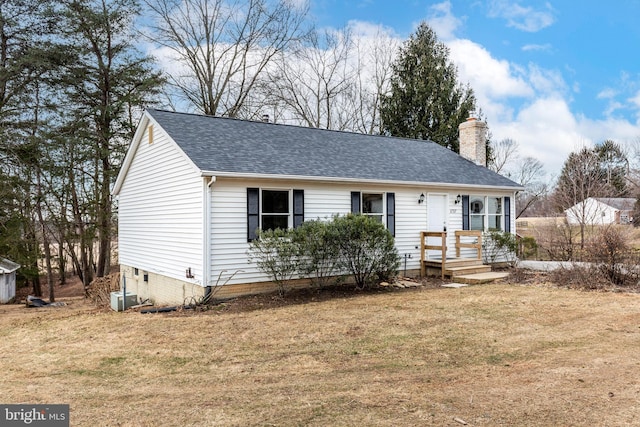 view of front of home with central AC and a front lawn