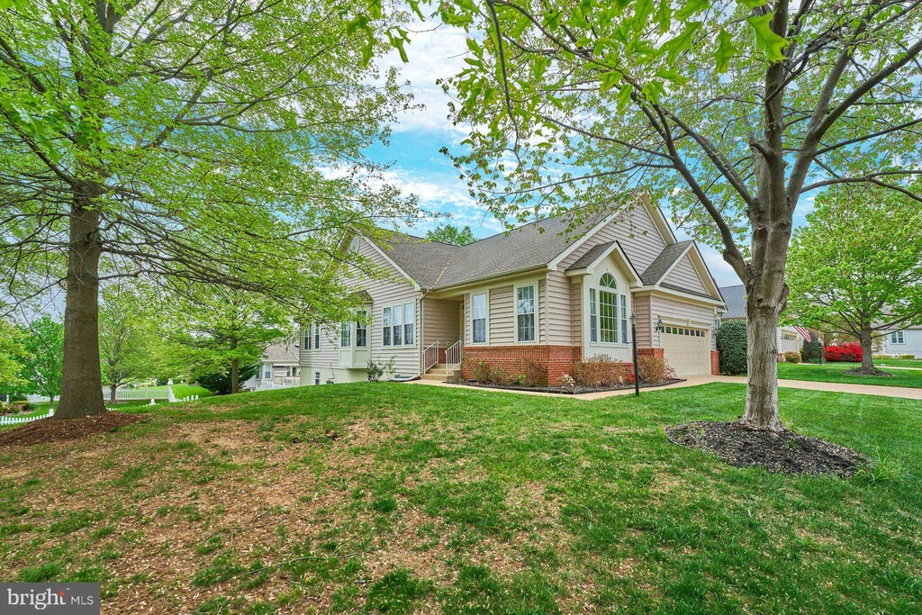 14064 Breeders Cup Dr, Gainesville, VA 20155 - view of front of property featuring concrete driveway, a front lawn, an attached garage, and brick siding