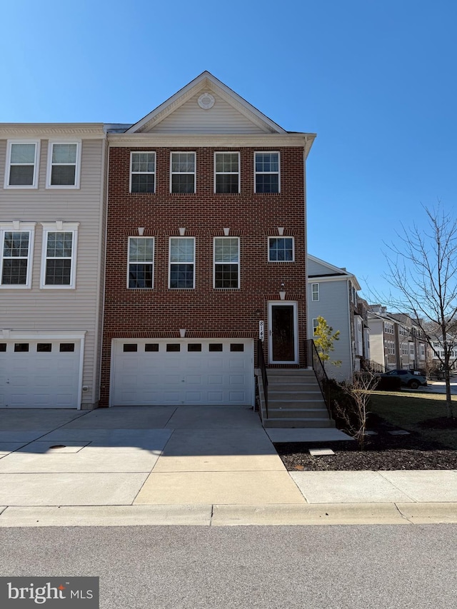 view of front facade with brick siding, driveway, and an attached garage