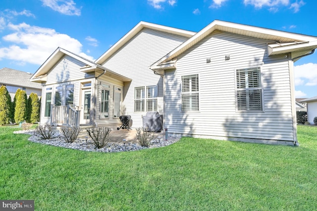 rear view of property featuring a lawn and a patio area