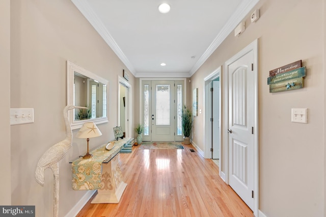 foyer featuring crown molding and light hardwood / wood-style floors