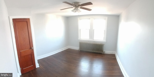 spare room featuring ceiling fan, dark hardwood / wood-style flooring, and radiator