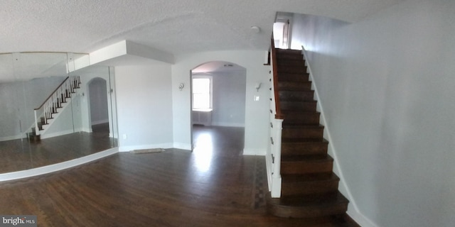 stairway featuring a textured ceiling and hardwood / wood-style floors