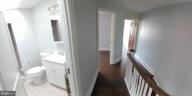 corridor featuring sink and light tile patterned flooring