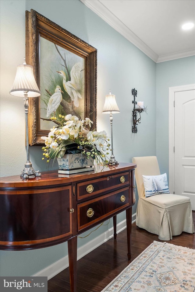 sitting room with baseboards, dark wood finished floors, and crown molding