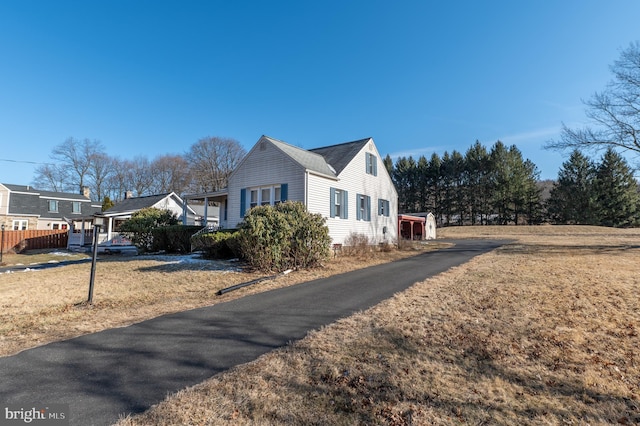 view of side of property with a carport, a residential view, and a lawn