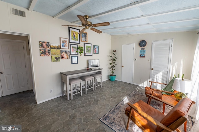 interior space featuring ceiling fan, beam ceiling, visible vents, and baseboards