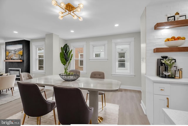 dining room featuring baseboards, light wood finished floors, and recessed lighting