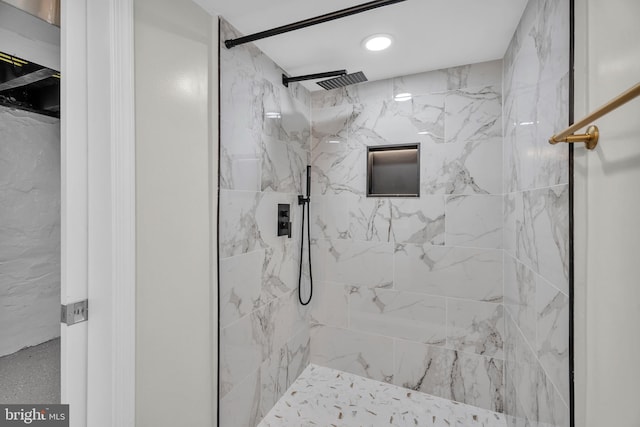 bathroom featuring a marble finish shower