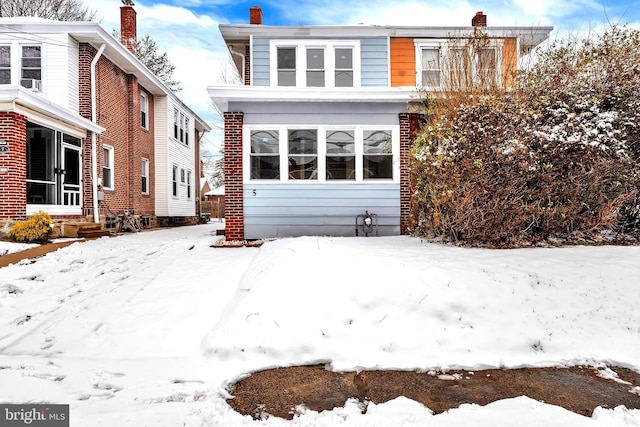 snow covered property with a chimney