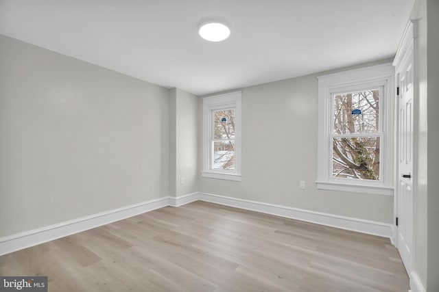 spare room featuring light wood-type flooring and baseboards