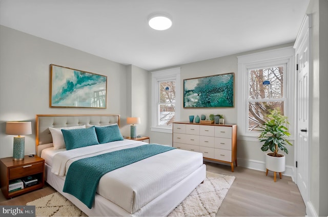 bedroom featuring light wood-style flooring and baseboards