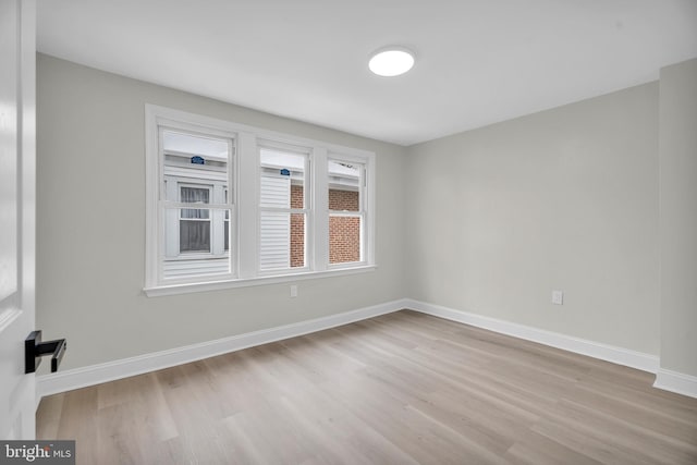 spare room featuring light wood-style flooring and baseboards