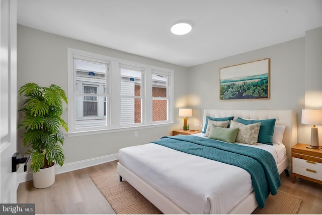 bedroom featuring light wood-style flooring and baseboards