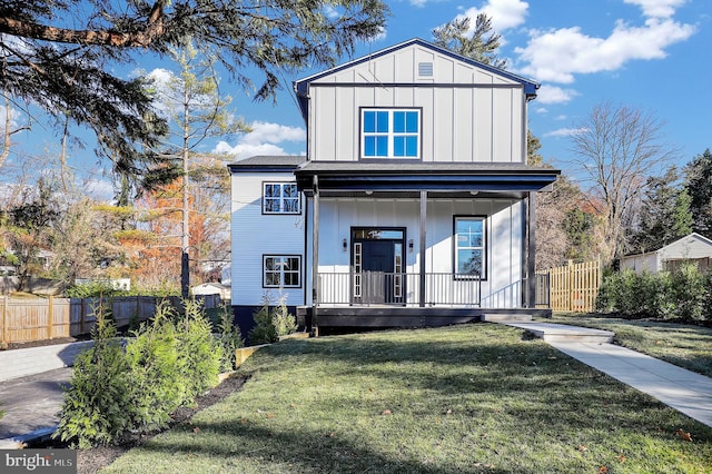 view of front facade with a porch, board and batten siding, a front yard, and fence